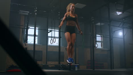 Strong-muscular-young-woman-rope-skipping-as-warm-up.-Fitness-concept.-Young-slim-woman-jumping-with-skipping-rope-in-gym.-Close-up-of-female-feet-jumping-in-mid-air-whilst-using-skipping-rope.